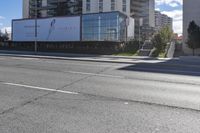 a white street sign mounted to the side of a white building on a city street