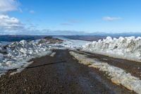 two snow - covered roads lead up to the top of a mountain on a clear day