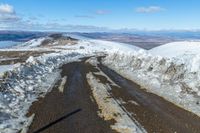 two snow - covered roads lead up to the top of a mountain on a clear day