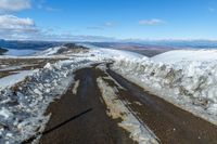 two snow - covered roads lead up to the top of a mountain on a clear day