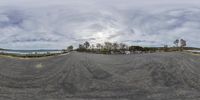 a 360 - view picture shows how the sky looks like over the ocean and beach