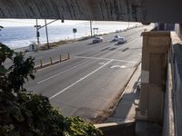 the view from a tunnel that is over an open street, looking at an ocean and freeway