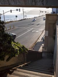 the view from a tunnel that is over an open street, looking at an ocean and freeway