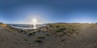 a 360 - view panoramic view of the ocean from a rocky beach at dusk