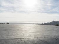 a view of some big rocks and water in the background with a sun on top