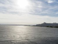 a view of some big rocks and water in the background with a sun on top