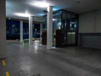 a empty commercial space is lit by lights from the city windows above the area at night