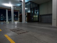 a empty commercial space is lit by lights from the city windows above the area at night