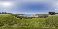 this is a photo of some grassy hills and the ocean by itselfs from the same point in the time