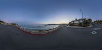 a panoramic image of a beach in front of a house and the ocean