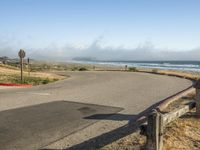 a quiet street by the ocean with no cars on it for a good view of the water