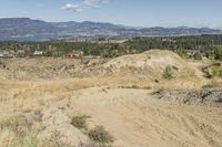 there is a bike rider on a paved dirt road through rocky area near a mountain