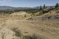 there is a bike rider on a paved dirt road through rocky area near a mountain