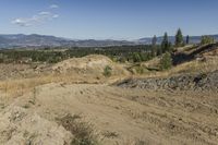 there is a bike rider on a paved dirt road through rocky area near a mountain