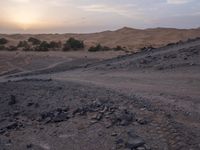 a truck on a dirt road in the desert with rocks and stones on the ground