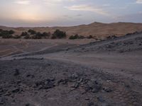 a truck on a dirt road in the desert with rocks and stones on the ground