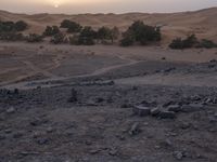a truck on a dirt road in the desert with rocks and stones on the ground