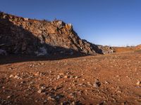 red rocks in an empty, barren landscape, under a clear blue sky, with no clouds