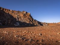 red rocks in an empty, barren landscape, under a clear blue sky, with no clouds