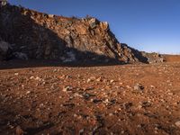 red rocks in an empty, barren landscape, under a clear blue sky, with no clouds