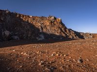 red rocks in an empty, barren landscape, under a clear blue sky, with no clouds