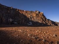 red rocks in an empty, barren landscape, under a clear blue sky, with no clouds