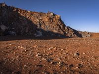 red rocks in an empty, barren landscape, under a clear blue sky, with no clouds