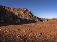 red rocks in an empty, barren landscape, under a clear blue sky, with no clouds