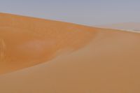 man standing in sand dunes and looking out at the beach area for ocean or ocean to come