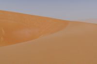 man standing in sand dunes and looking out at the beach area for ocean or ocean to come