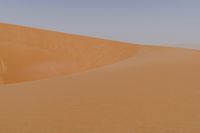 man standing in sand dunes and looking out at the beach area for ocean or ocean to come