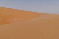 man standing in sand dunes and looking out at the beach area for ocean or ocean to come