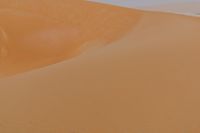 man standing in sand dunes and looking out at the beach area for ocean or ocean to come