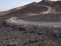 a truck on a dirt road in the desert with rocks and stones on the ground