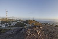 the view down the hill shows a winding road on either side of the valley leading to the city and the ocean