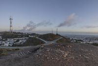 the view down the hill shows a winding road on either side of the valley leading to the city and the ocean