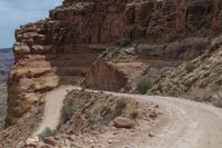 the road is rocky and empty of all traffic on it is a winding lane through mountains