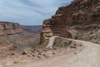 the road is rocky and empty of all traffic on it is a winding lane through mountains