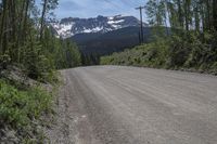 a car is on the side of an empty road with a mountain and sky in the background