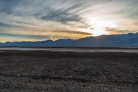 a lone fire hydrant on a deserted beach in the middle of nowhere, during sunset