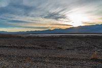 a lone fire hydrant on a deserted beach in the middle of nowhere, during sunset