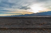 a lone fire hydrant on a deserted beach in the middle of nowhere, during sunset