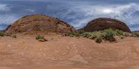 a lone car is parked in front of the red rocks of the desert area outside