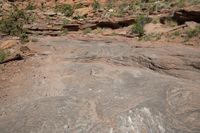 a woman standing in front of some rocks looking down on a bike ride through the wilderness