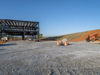 a picture of a building being built on a field near a forest in the background