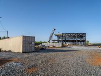 a picture of a building being built on a field near a forest in the background