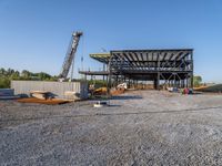 a picture of a building being built on a field near a forest in the background