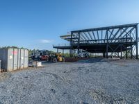 a picture of a building being built on a field near a forest in the background