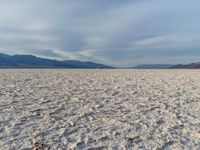 the empty dry desert is covered in sand and mountains in the distance's horizon