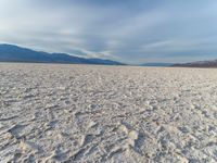 the empty dry desert is covered in sand and mountains in the distance's horizon